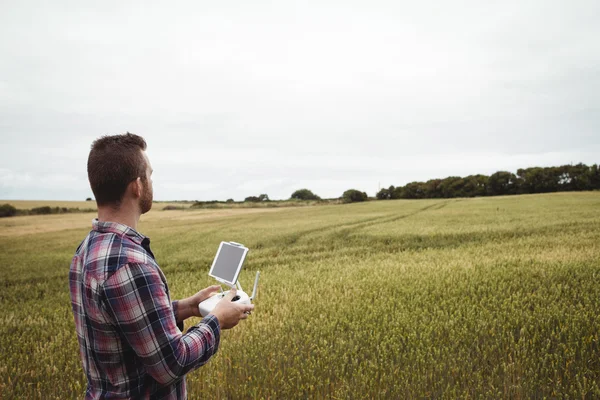 Farmer using agricultural device while examining in field — Stock Photo, Image
