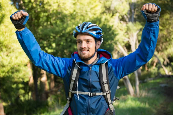 Podekscytowany mężczyzna mountain biker w lesie — Zdjęcie stockowe