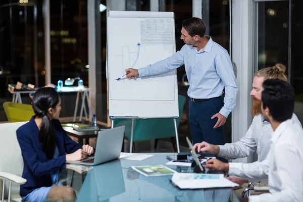 Empresário discutindo gráfico no quadro branco — Fotografia de Stock