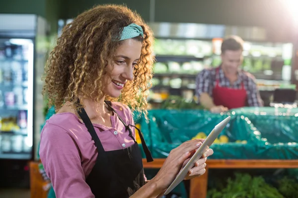 Personeel met behulp van digitale tablet in de biologische sectie — Stockfoto