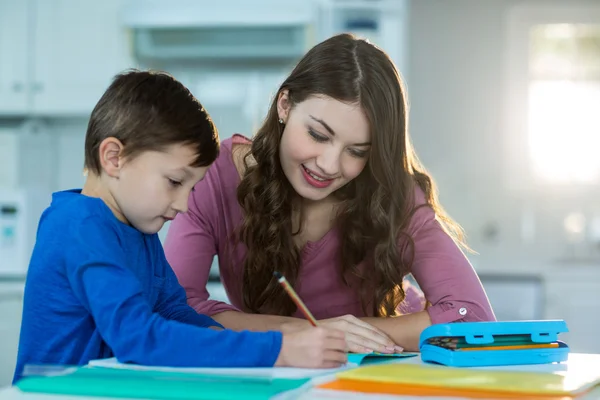 Moeder haar zoon helpen met huiswerk — Stockfoto