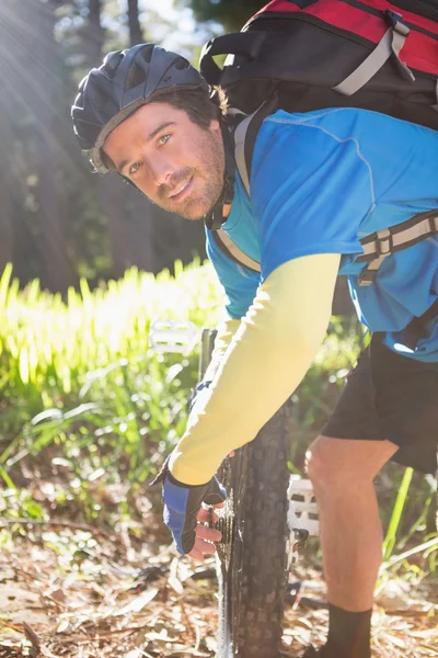 Портрет чоловічого гірського велосипедиста, що фіксує свій велосипедний ланцюг — стокове фото