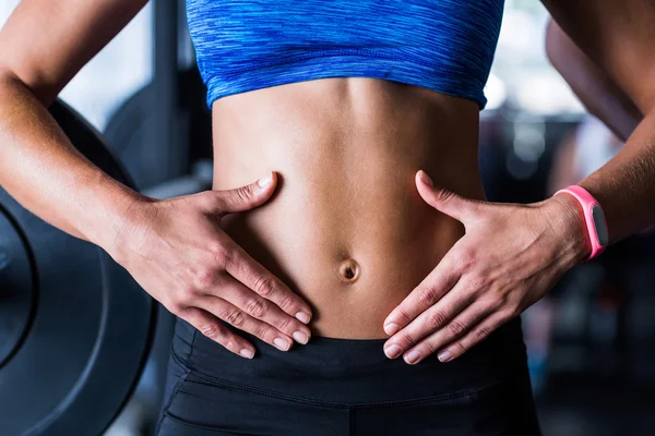 Athlete touching belly in gym — Stock Photo, Image
