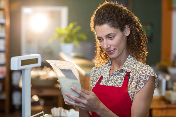 Staff looking at grocery item at counter — Stock Photo, Image