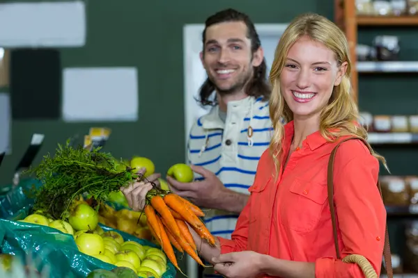 Pareja seleccionando frutas y zanahorias — Foto de Stock