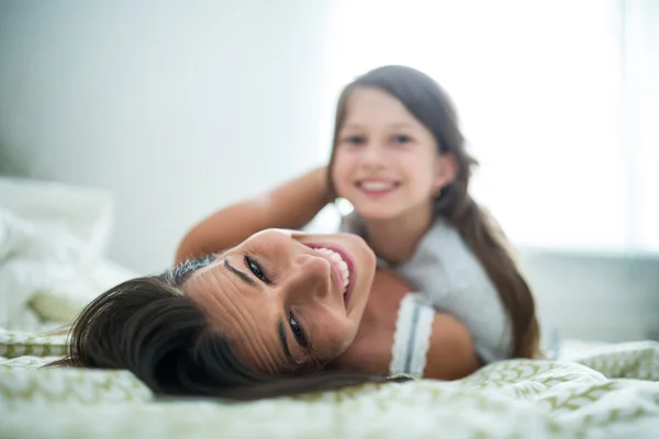 Moeder en dochter liggen in slaapkamer — Stockfoto