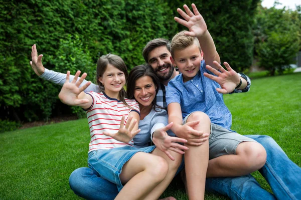 Aile güneşli parkta çimenlerin üzerinde — Stok fotoğraf