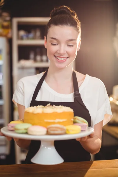 Waitress holding cake on tray — Stock Photo, Image