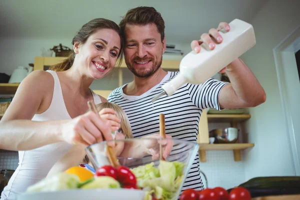 Family preparing salad in the kitchen — Stockfoto