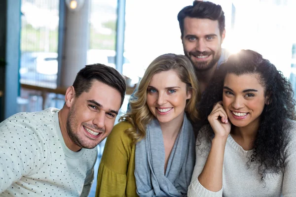 Vrienden poseren in café — Stockfoto