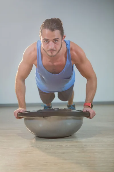 Man gör push-up på bosuball — Stockfoto