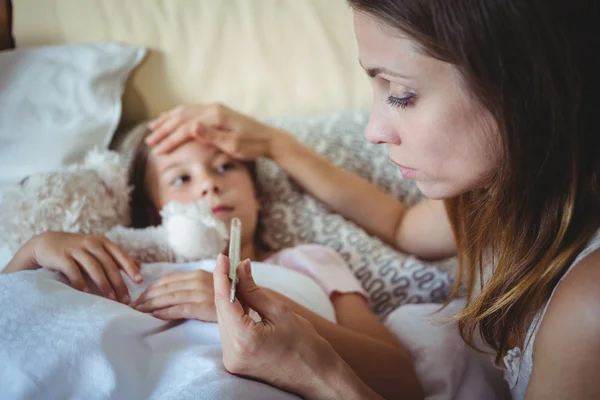 Anne kızı sıcaklık termometre üzerinde kontrol — Stok fotoğraf