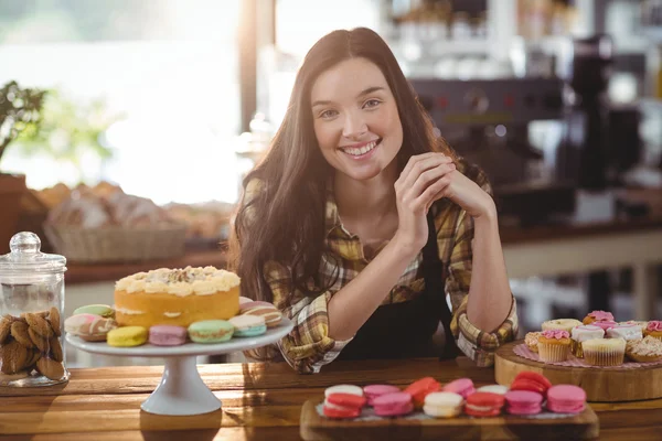 Waitress standing at counter with desserts — Stock Photo, Image