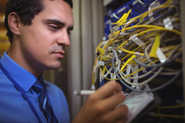 Técnico mantendo o registro do servidor montado em rack — Fotografia de Stock