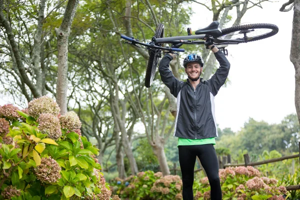 Male cyclist carrying mountain bike — Stock Photo, Image