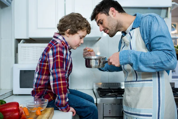 Pai e filho cozinhando comida juntos — Fotografia de Stock