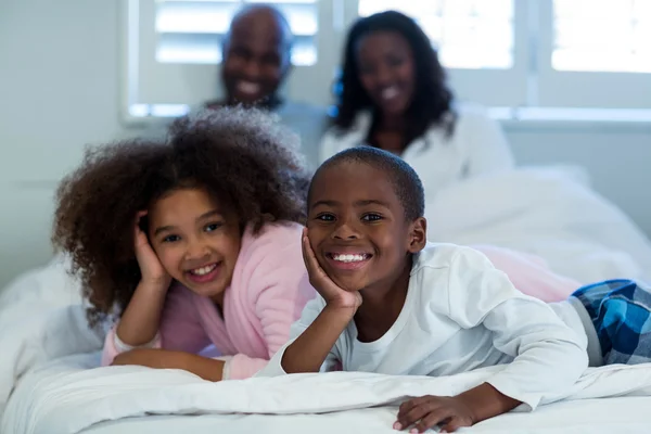 Niños acostados en la cama con sus padres —  Fotos de Stock