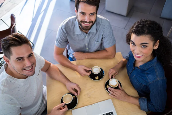 Amis souriants assis à une table — Photo