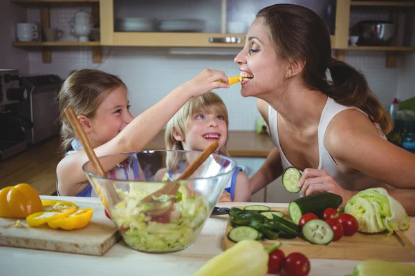 Kids feeding pepper to mother — Stock Photo, Image