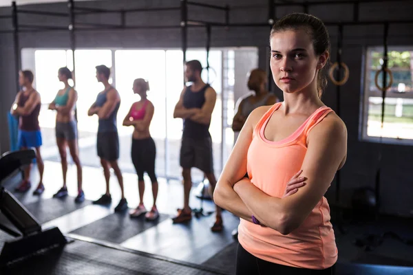 Atleta femenina con brazos cruzados en gimnasio — Foto de Stock