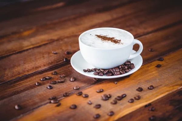 Kaffeetasse und Bohnen auf einem Tisch — Stockfoto