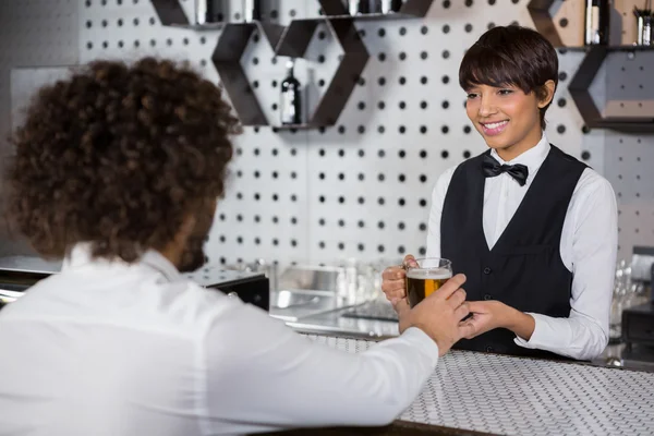 Barmaid serving drink to man — Stock Photo, Image