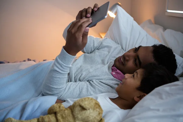 Πατέρας και γιος χρησιμοποιώντας tablet στο κρεβάτι — Φωτογραφία Αρχείου