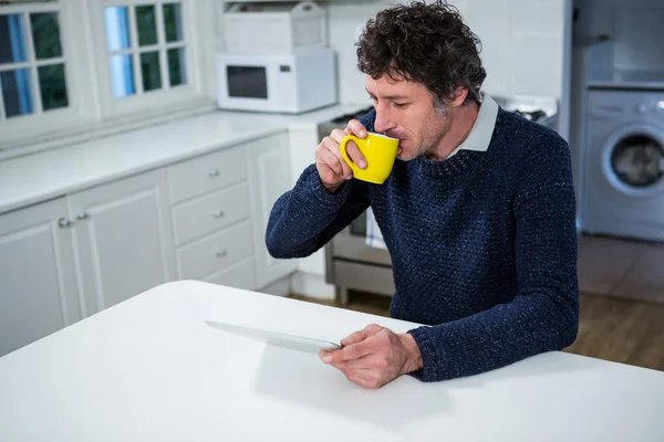 Uomo che utilizza tablet mentre prende il caffè — Foto Stock