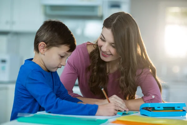Madre aiutare suo figlio con i compiti — Foto Stock