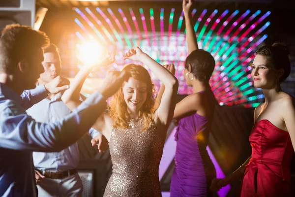 Smiling friends dancing on dance floor