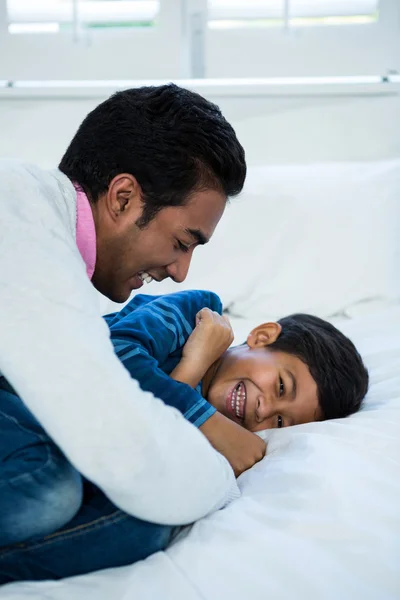 Vater und Sohn spielen auf dem Bett — Stockfoto