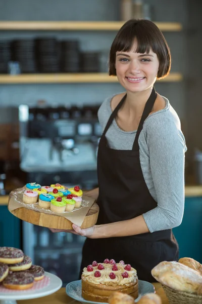 Servitris hålla kaka på bricka — Stockfoto