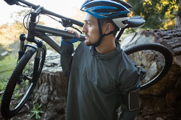 Male mountain biker carrying bicycle — Stock Photo, Image