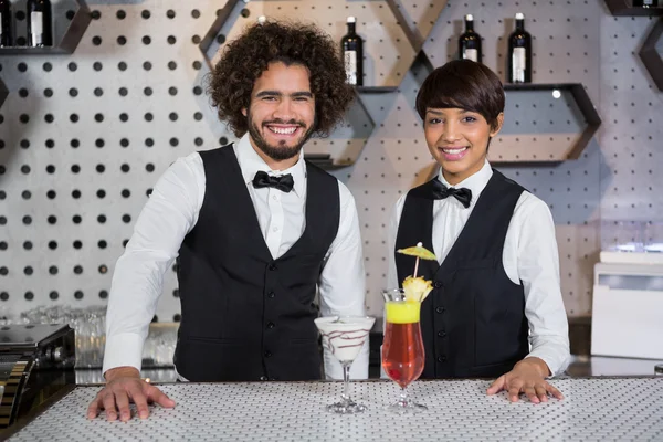 Camarera y camarero de pie en el mostrador del bar con vaso de cóctel — Foto de Stock