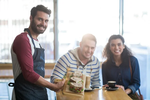 Ober plaat voor sandwich serveren aan klant — Stockfoto