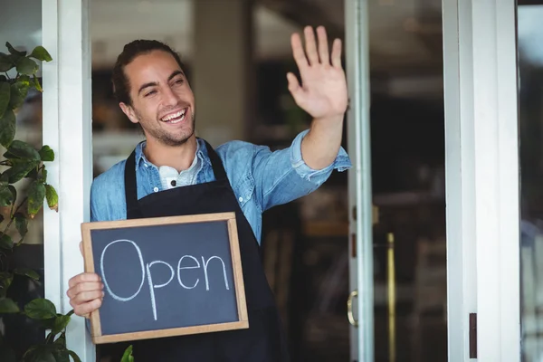 Waiter holding chalkboard with open sign — Stock Photo, Image