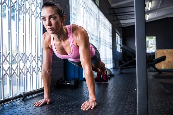 Jovem atleta do sexo feminino fazendo flexões — Fotografia de Stock