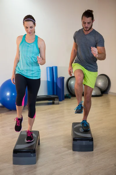 Mann und Frau bei Step-Aerobic-Übungen — Stockfoto