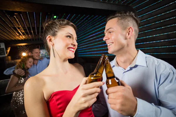 Paar stößt auf eine Bierflasche an — Stockfoto