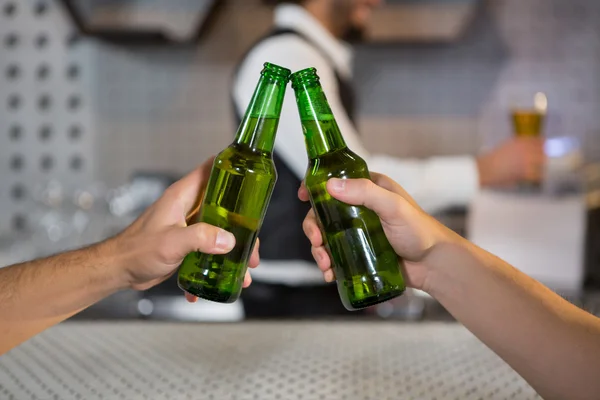 Twee mannen het roosteren van een flesje bier — Stockfoto