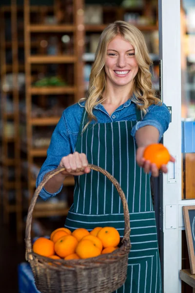 Staff holding basket of fruit in organic section — Stock Photo, Image