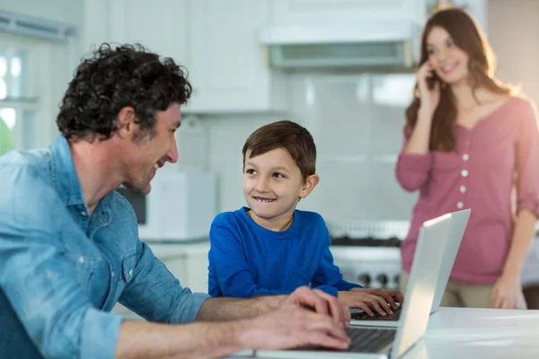 Pai e filho usando laptop — Fotografia de Stock