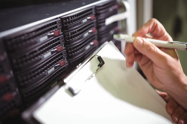 Technician maintaining record of rack mounted server — ストック写真