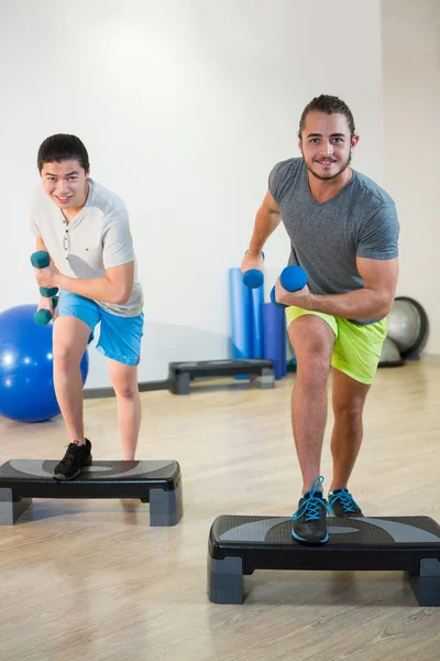 Hombres haciendo ejercicio aeróbico paso con mancuerna —  Fotos de Stock