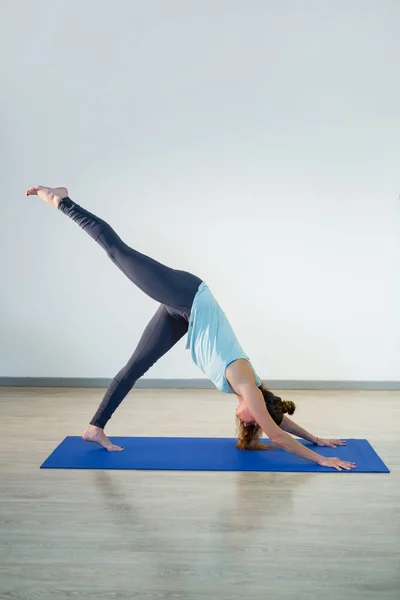 Mulher realizando ioga no tapete de exercício — Fotografia de Stock