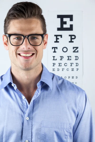 Muž nosí brýle s oko chart — Stock fotografie