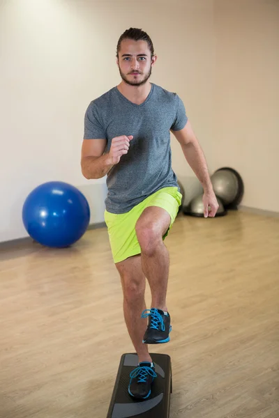 Homme sérieux faisant de l'exercice sur stepper aérobie — Photo