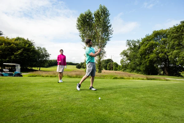 Instrutor assistindo mulher na aprendizagem de golfe — Fotografia de Stock