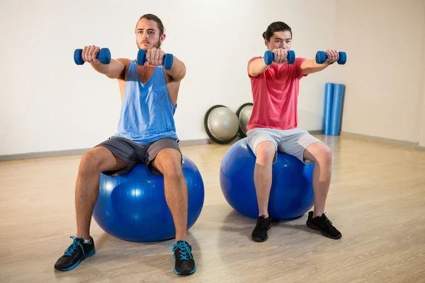 Hombres haciendo ejercicio sobre pelota de ejercicio —  Fotos de Stock