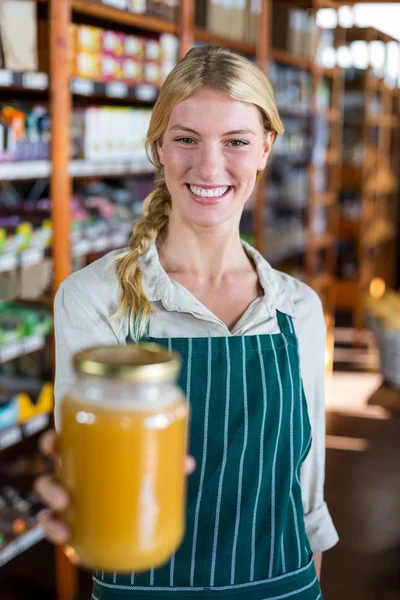 Anställda som innehar burk honung i stormarknad — Stockfoto